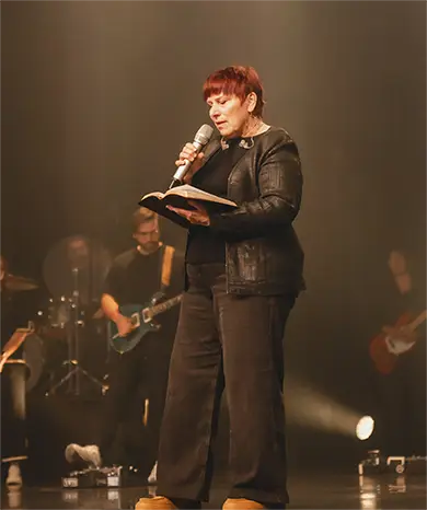 pastor standing on stage hands folded