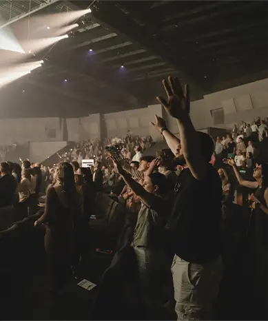pastor standing on stage hands folded