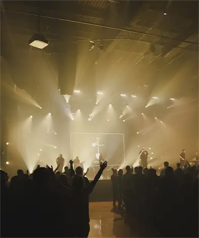 pastor standing on stage hands folded