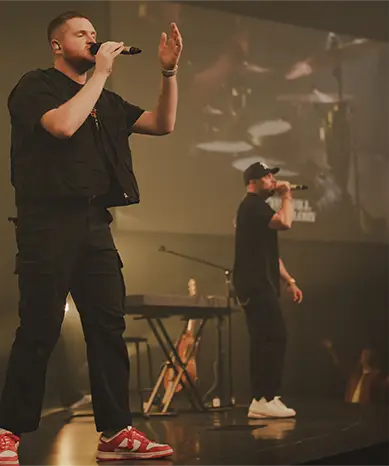 pastor standing on stage hands folded