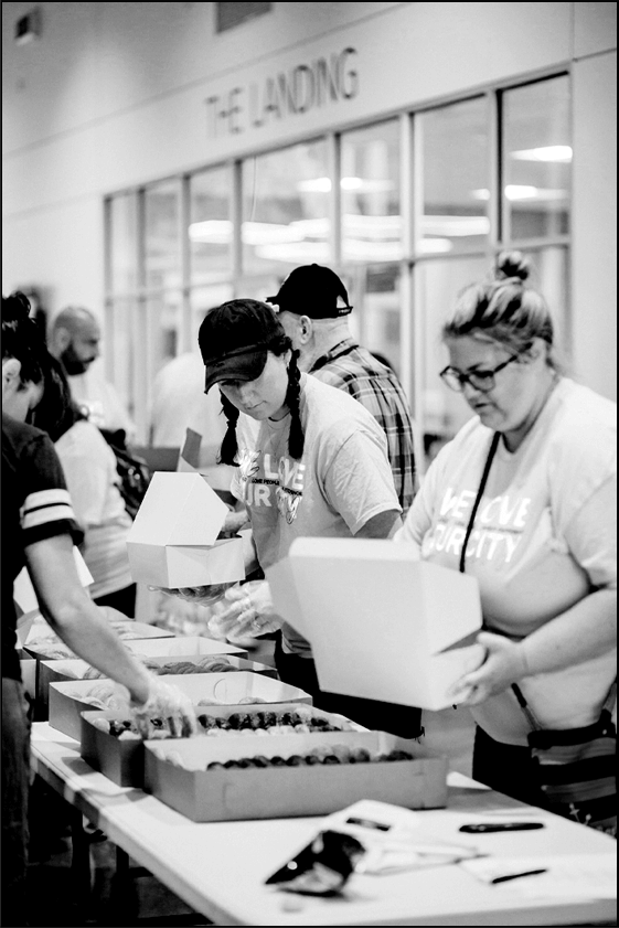 black and white photo of women packing food boxes
