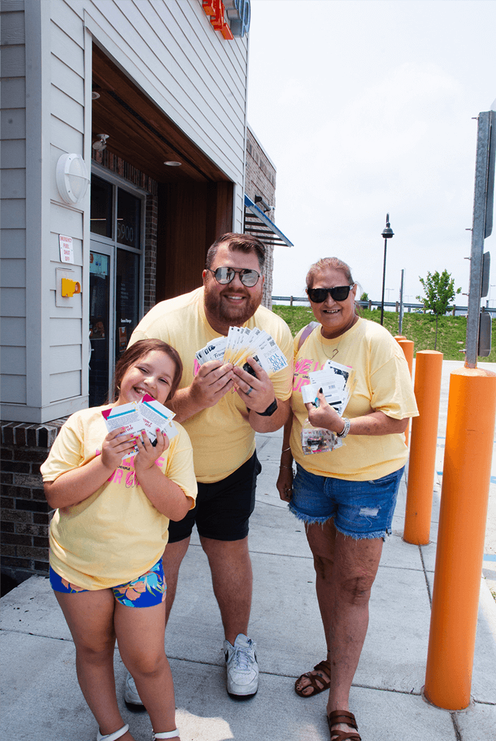3 volunteers posing and holding little boxes
