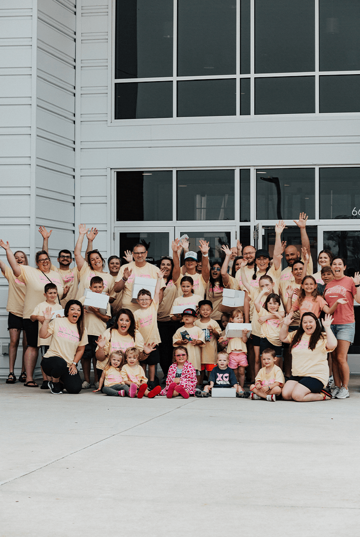 crowd of people raising hands and waving, posing for picture